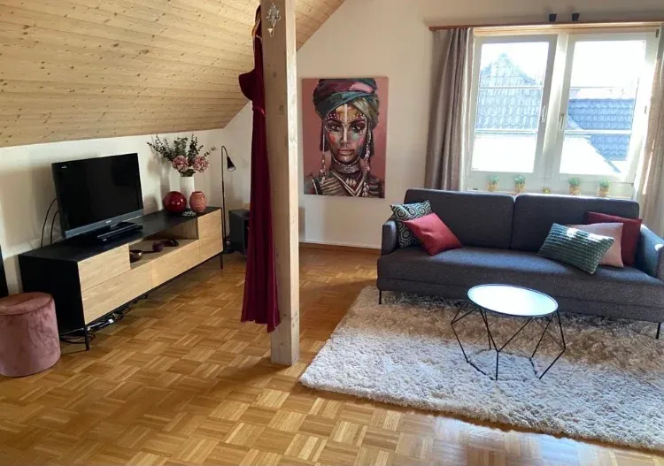 Offener Wohnbereich mit Sofa, Kunst und Raumteiler